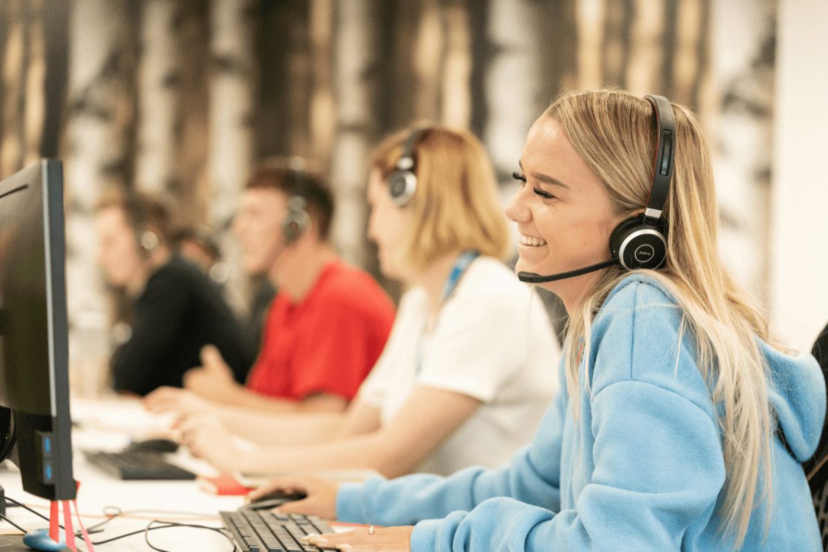 Photo of customer support agent smiling on the phone
