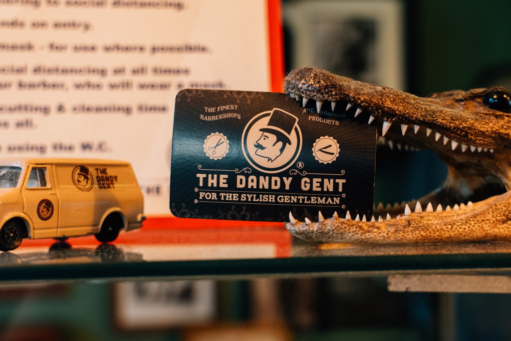A The Dandy Gent business card sits inside the mouth of a crocodile head