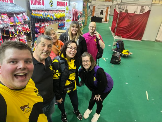 The Paws Trading team line up and smile in front of their booth at Crufts Dog Show