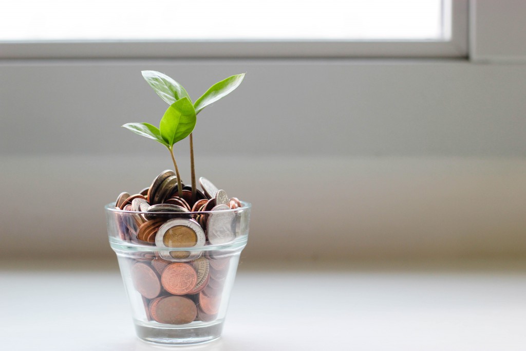a cup full of change sits on a windowsill