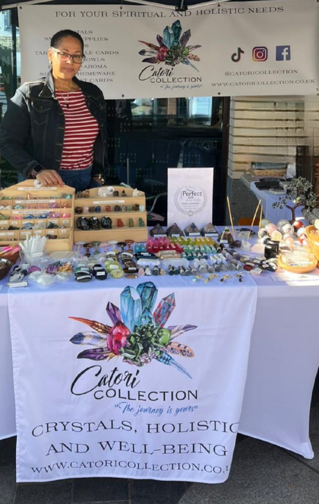 Candice stands proudly in front of her Catori Collection table at a fair